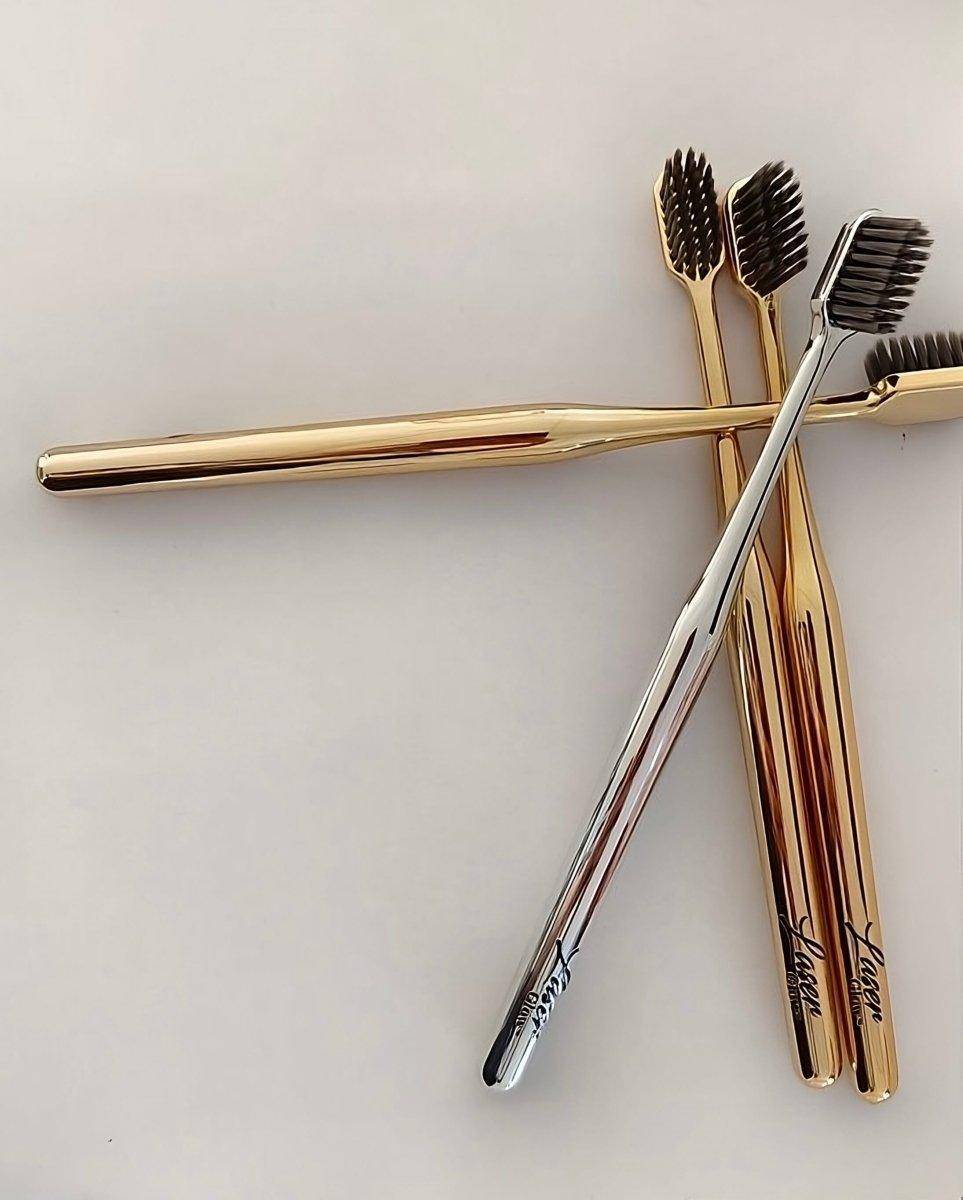 Elegant LaserGlow gold and silver soft bristle toothbrush for premium oral care.