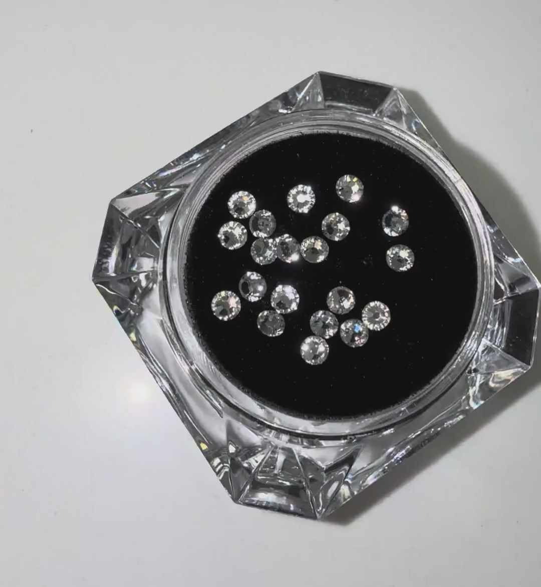Load video: Close-up video of LaserGlow Swarovski tooth gems sparkling with high-shine light reflections on enamel.