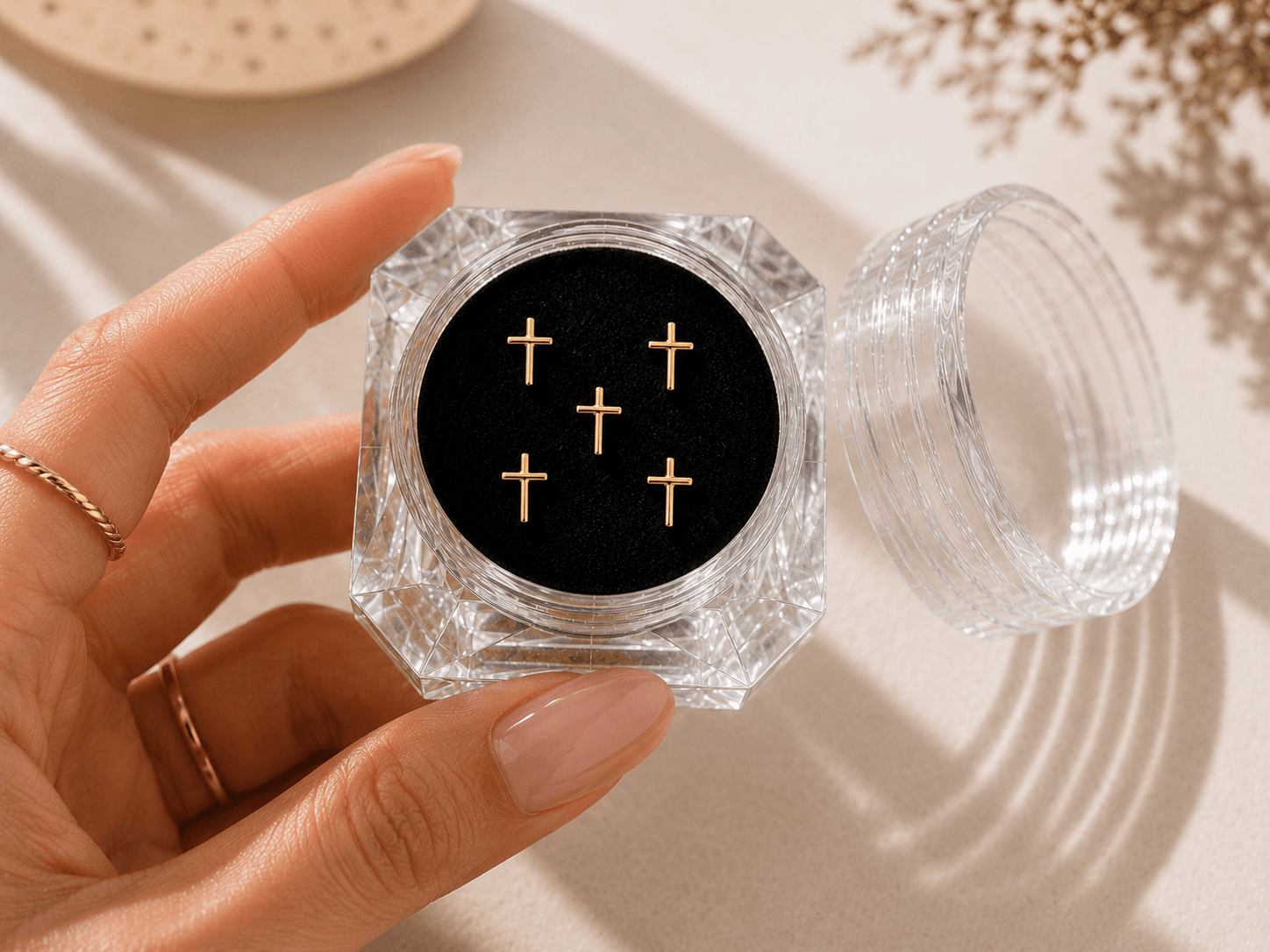 Five gold plated cross tooth gems in a faceted acrylic display case for tooth gem application