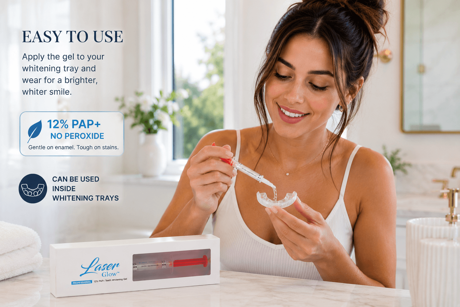 Woman applying LaserGlow 12% PAP+ no peroxide teeth whitening gel into a whitening tray in a bright bathroom