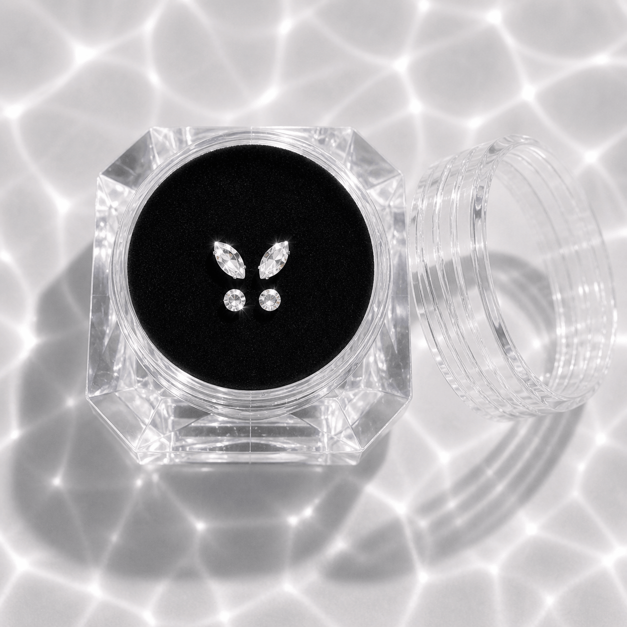 Clear container with butterfly-shaped gemstones on a black background