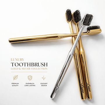 LaserGlow gold and silver soft bristle toothbrushes with metallic handles and black bristles for luxury oral care