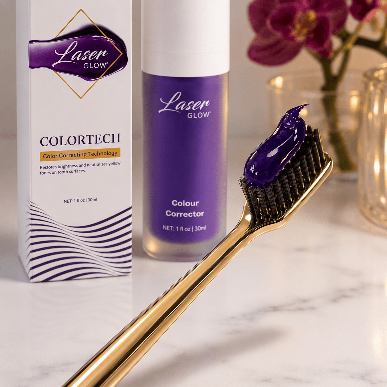 LaserGlow purple serum toothpaste color corrector applied on a gold toothbrush with product bottle and box packaging in the background for neutralizing yellow tones