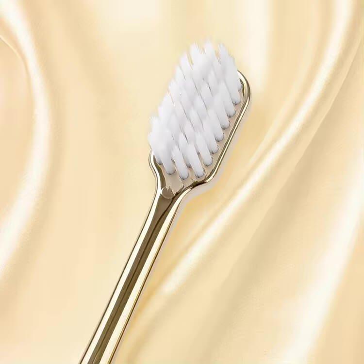 LaserGlow gold and silver soft bristle toothbrush for superior plaque removal and comfort.