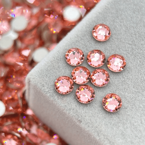 Peach high-shine round crystal tooth gems on velvet pad for professional tooth jewelry application by LaserGlow