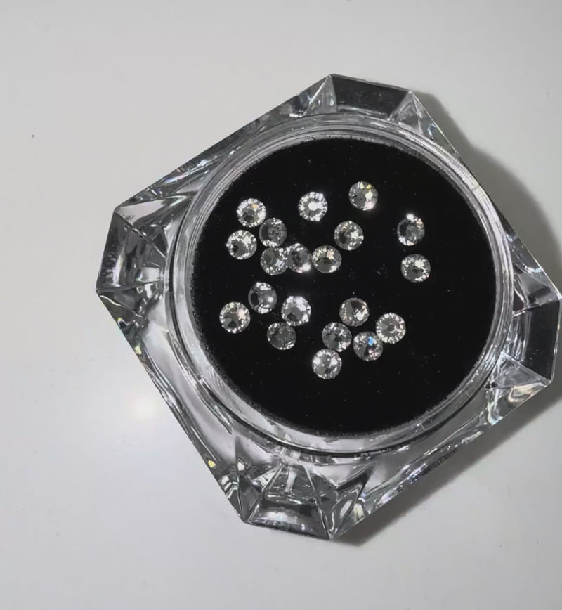 Close-up video of LaserGlow Swarovski tooth gems sparkling with high-shine light reflections on enamel.