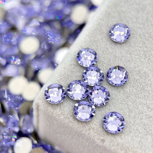 Purple high-shine round crystal tooth gems on velvet pad for professional tooth jewelry application by LaserGlow