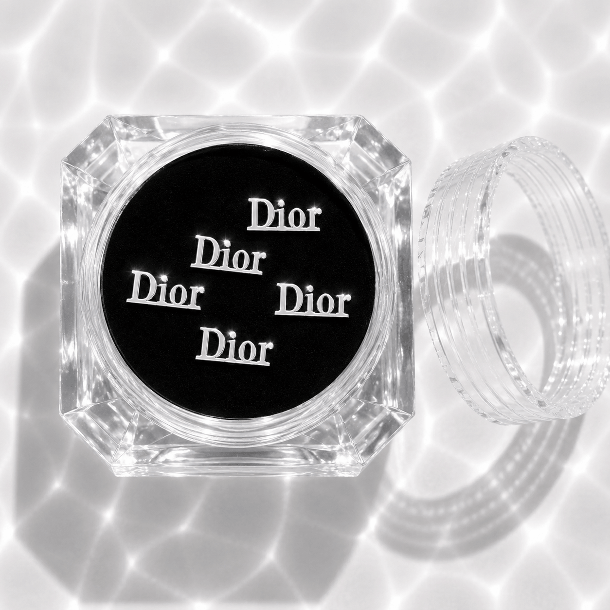 Five silver designer dior tooth gem charms in a clear acrylic display case