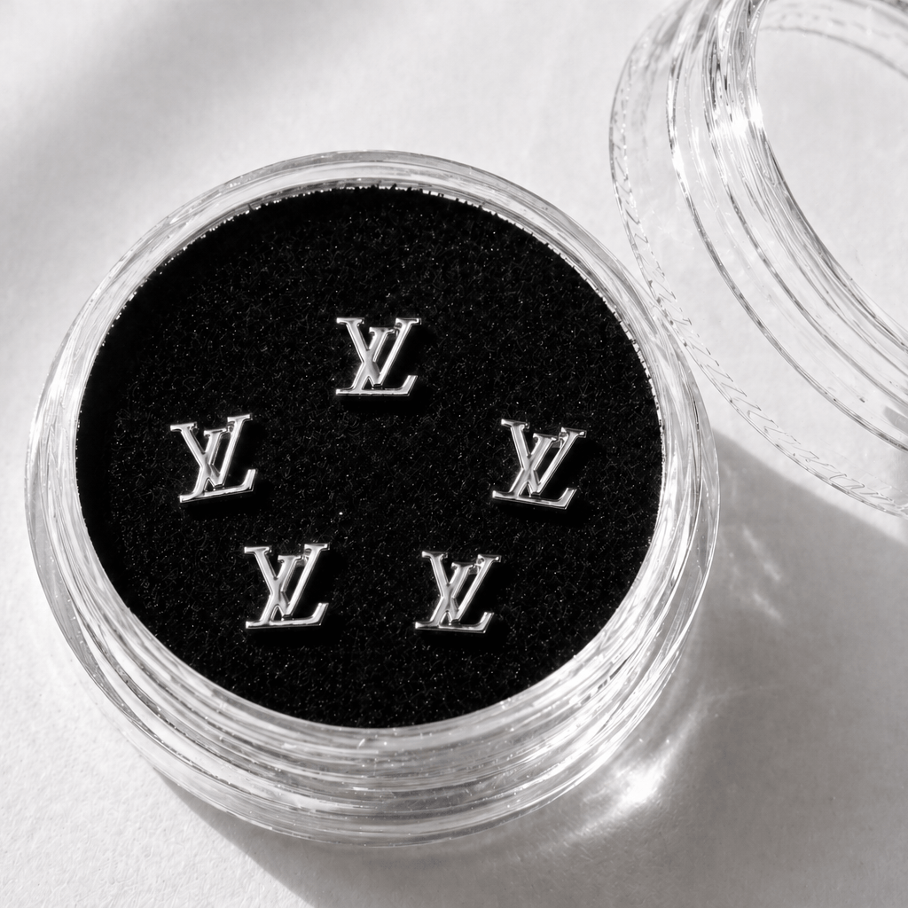Silver LV-inspired tooth gems 5-pack displayed in an acrylic case with black velvet insert for luxury tooth jewelry.