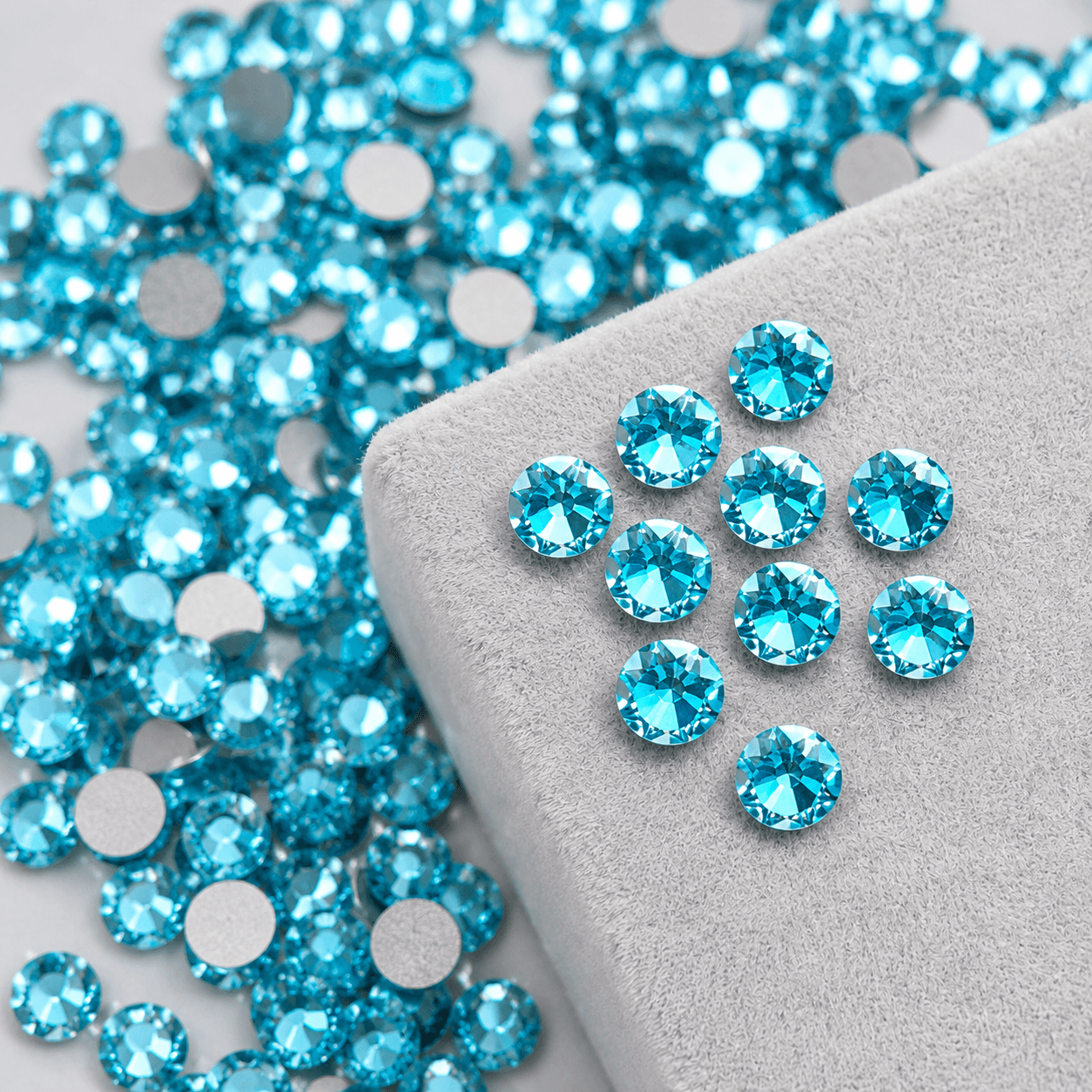 turquoise blue high-shine round crystal tooth gems on velvet pad for professional tooth jewelry application by LaserGlow