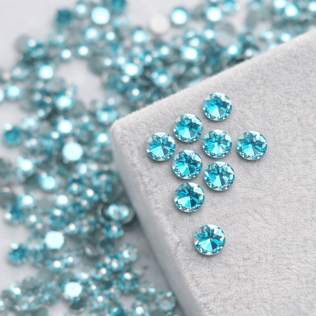 Turquoise crystal tooth gems displayed on a soft gray velvet surface for smile jewelry styling